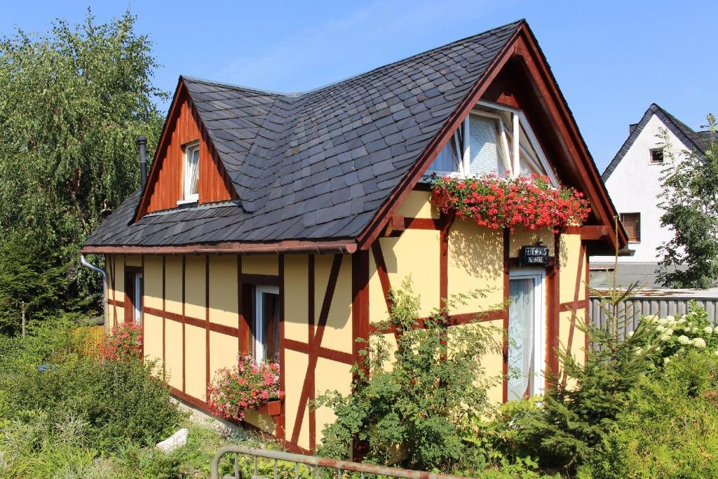 una casa amarilla y naranja con techo negro en Ferienhaus Neubert, en Wolkenstein