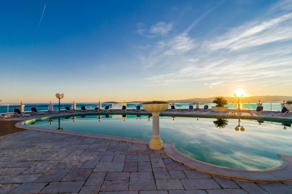 a swimming pool with the ocean in the background at Pansion Villa Antonio in Orebić