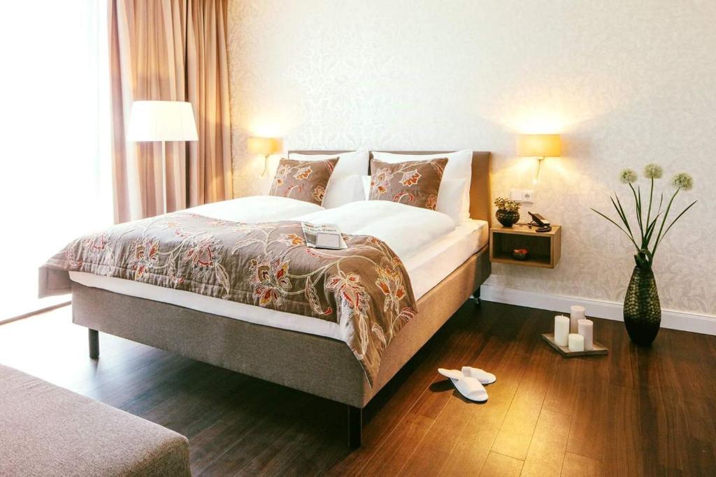 a bedroom with a large bed and a wooden floor at Chester Hotel Heidelberg in Heidelberg