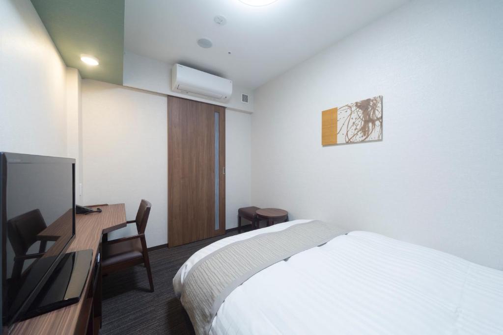 Postel nebo postele na pokoji v ubytování Myoujin-no-Yu Dormy Inn Premium Kanda