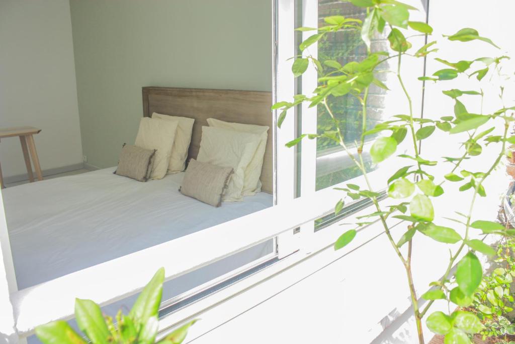 Cama en habitación con ventana en chambre d'hôte M et Mme Collet en Lille