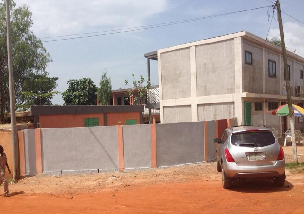 a small car parked in front of a building at Hotel Marie Antoinette Kara in Kara