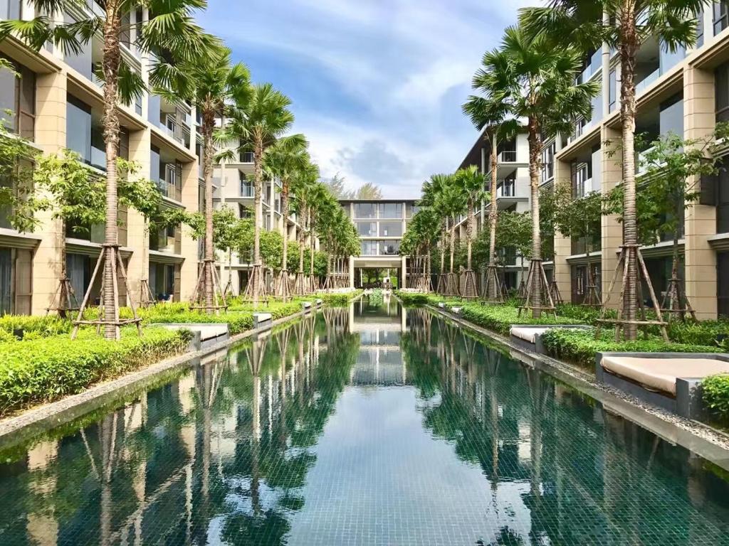 a canal in an apartment complex with palm trees at Baan mai khao apartment in Mai Khao Beach