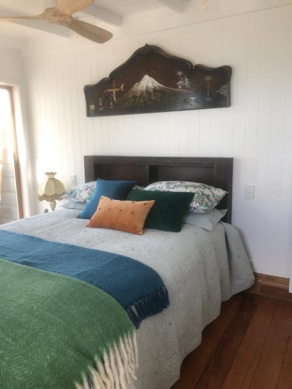 a bedroom with a bed and a painting on the wall at Little Church Bay in New Plymouth