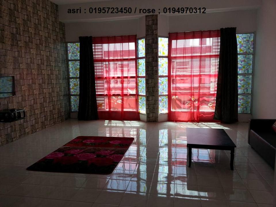 - un salon avec des fenêtres rouges et une table dans l'établissement GERIK HOMESTAY, à Gerik