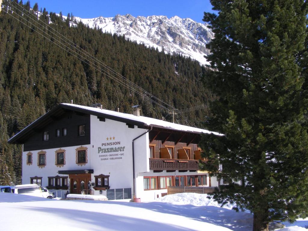 a building in front of a snow covered mountain at Pension Praxmarer in Sankt Sigmund im Sellrain