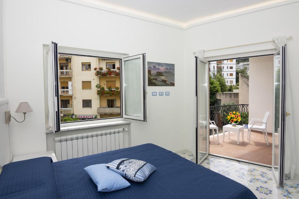 um quarto com uma cama azul e uma varanda em Ambra Sorrento Suites Short Rent em Sorrento