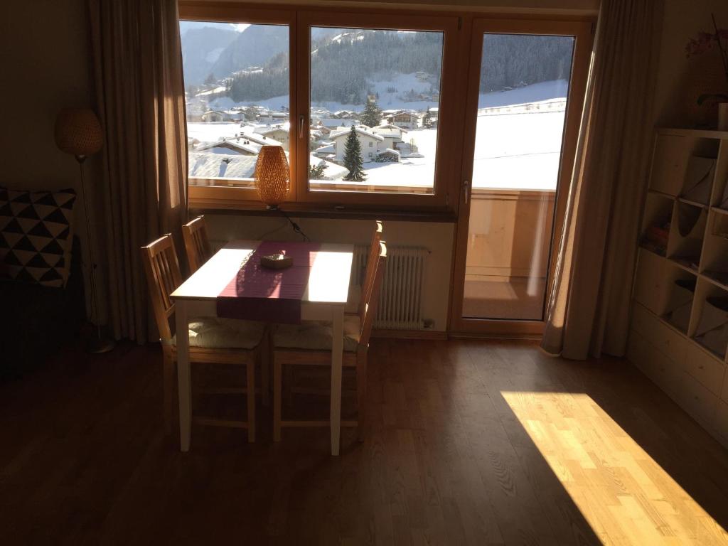 ヒパッハにあるAhorn Apartment Zillertalの窓のある部屋(テーブル、椅子付)