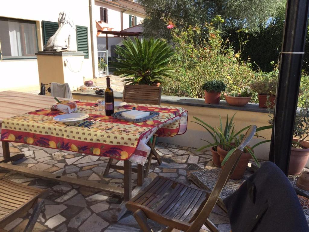 un tavolo con una bottiglia di vino seduto su un patio di Il giardino di Otto a Cascina