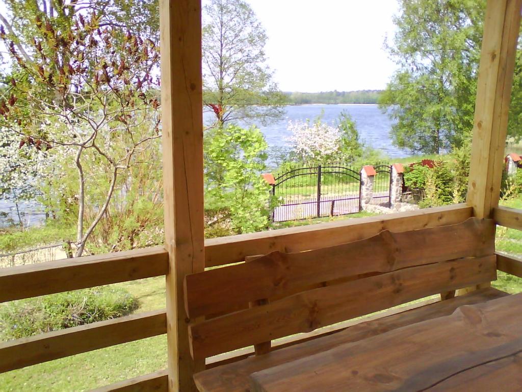 a view from the porch of a cabin with a view of the water at Domek nad Jeziorem in Ryn