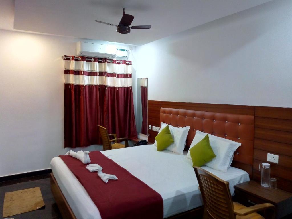 um quarto de hotel com uma cama, uma mesa e uma janela em Medavakkam Sri Sai Residency em Chennai