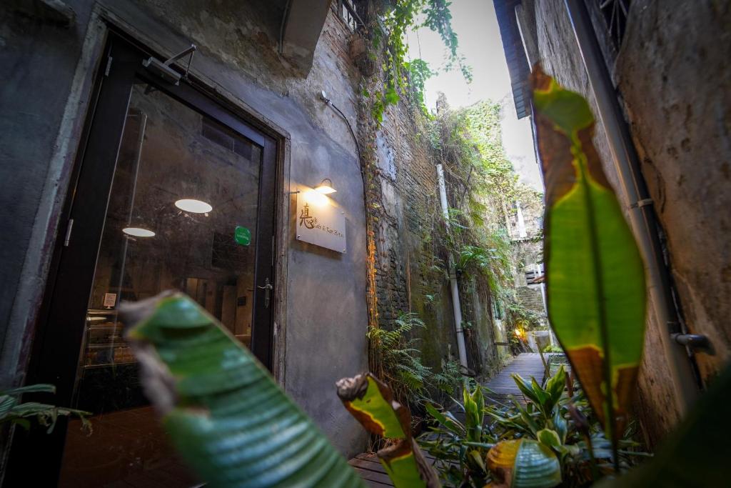 une fenêtre d'un bâtiment avec des plantes vertes devant lui dans l'établissement Dé Cafe & Rest House, à Ipoh