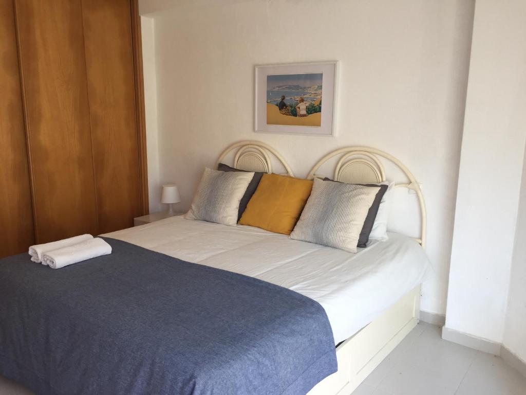 ein Schlafzimmer mit einem weißen Bett mit einer blauen Decke in der Unterkunft Golden Beach Apartment, Cabanas - Rua das Giestas Lote 4 J in Cabanas de Tavira