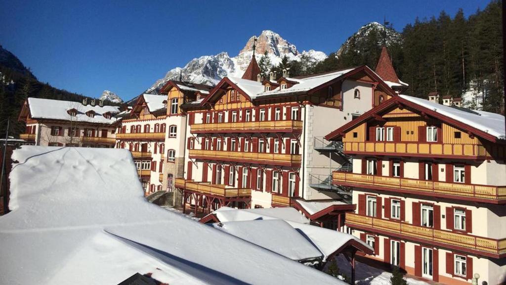 un grupo de edificios con techos nevados en MONOLOCALI del Villaggio PLONER Un passo dal cielo en Dobbiaco