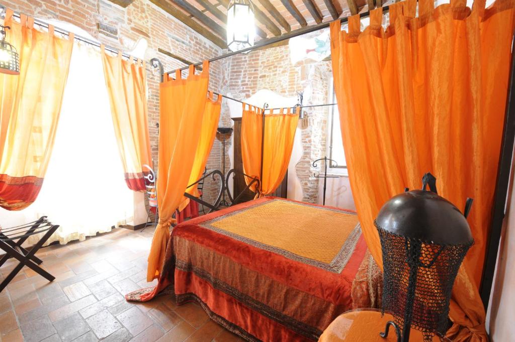 a bedroom with a bed with orange curtains at Antica Corte dei Principi charming rooms in Lucca