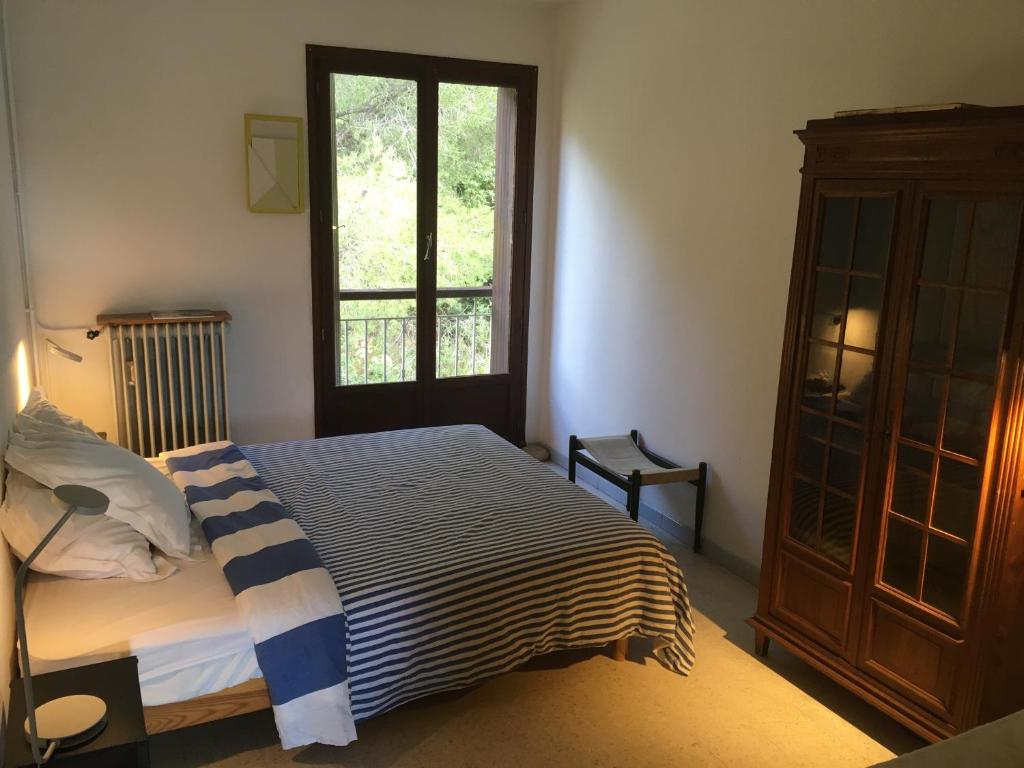 a bedroom with a bed and a large window at Appartement Cassis Plage in Cassis