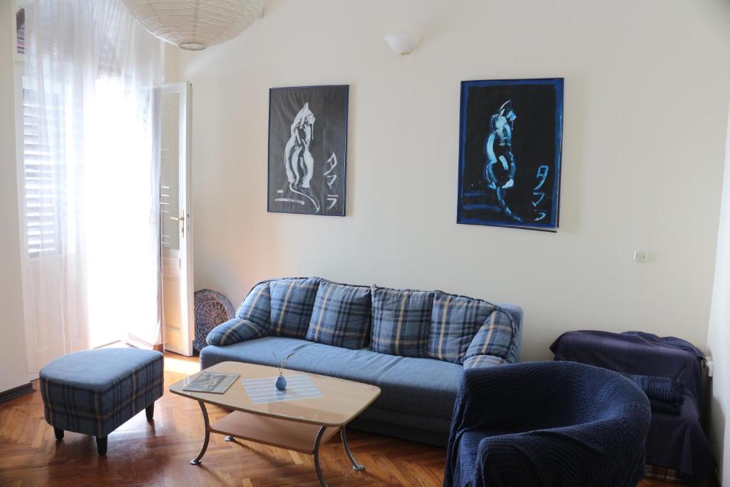 a living room with a blue couch and a table at Green Market Apartment in Opatija