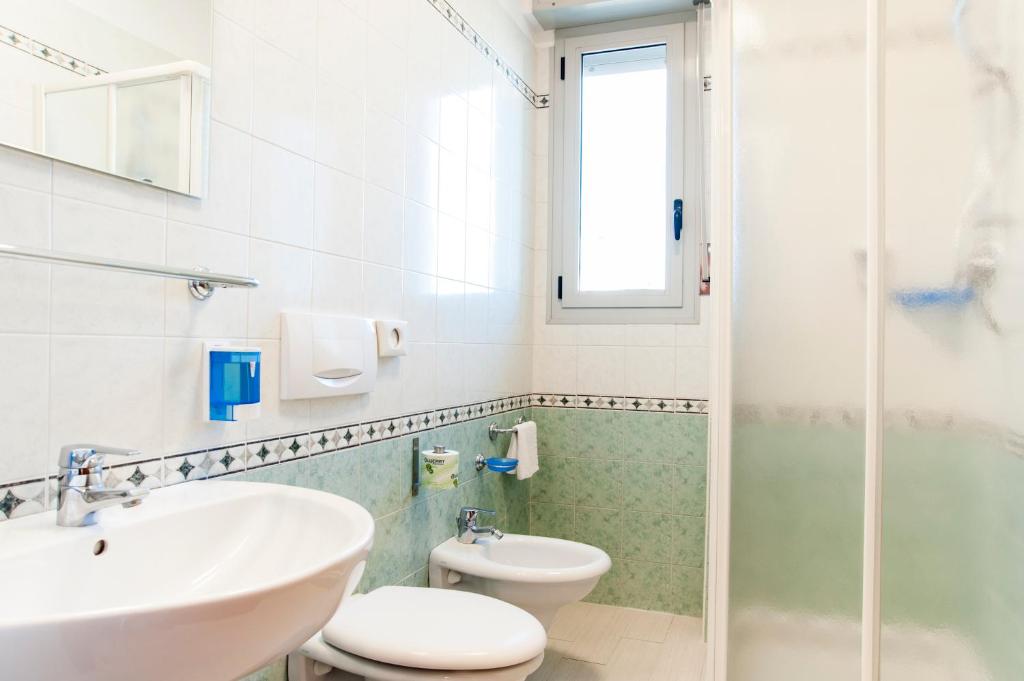 a bathroom with a sink and a toilet and a shower at Residence Cigno in Rimini