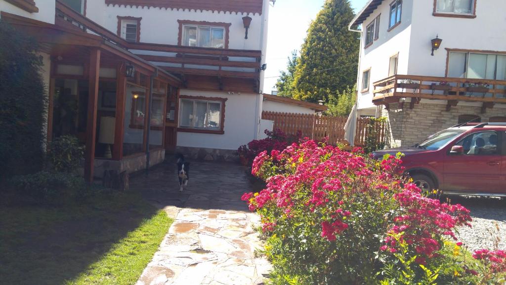 una casa con flores rosas delante de ella en Piuké en San Carlos de Bariloche