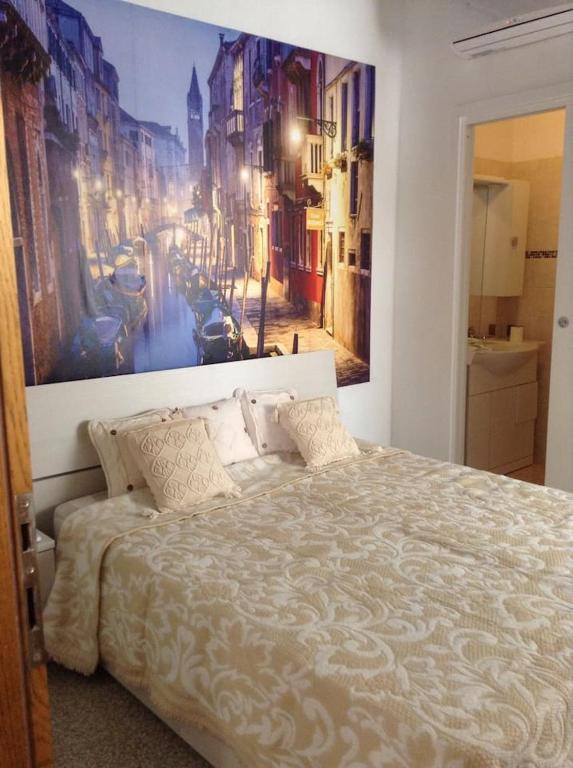 a bedroom with a bed with a painting on the wall at Comfort Murano room in Murano