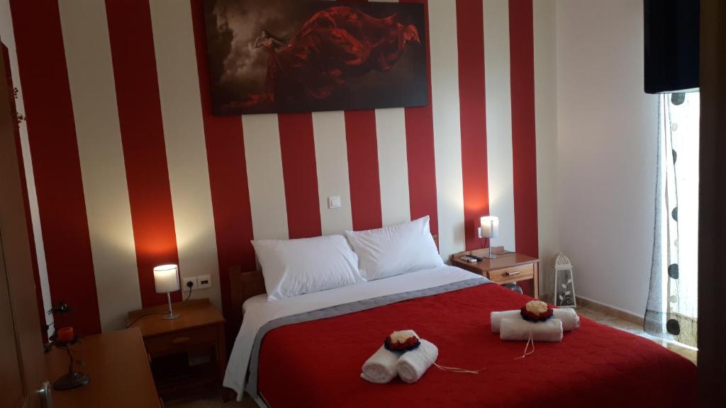 um quarto com uma parede listrada em vermelho e branco em Amalia's Apartments em Kissamos