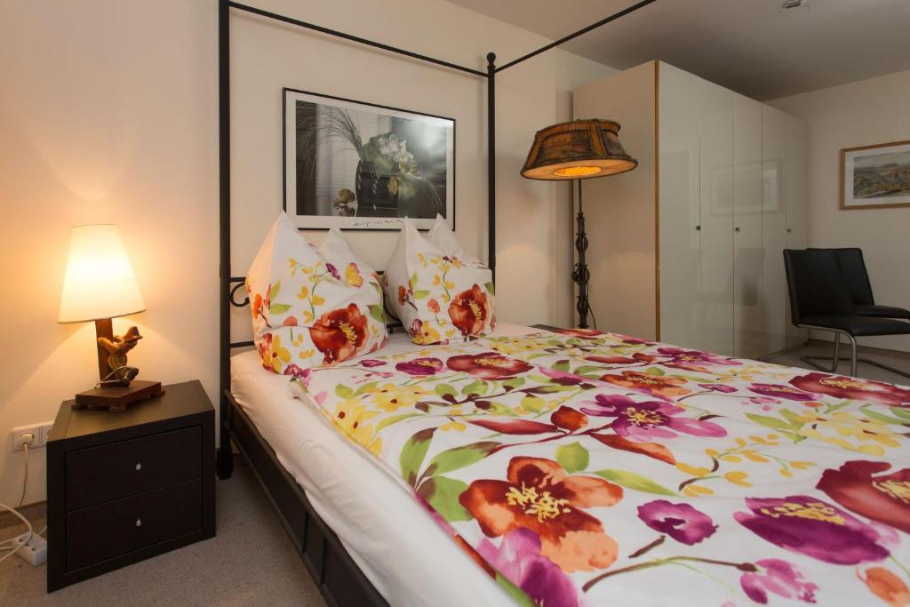 a bedroom with a large bed with a floral bedspread at Ferienwohnung Moritzburg in Boxdorf