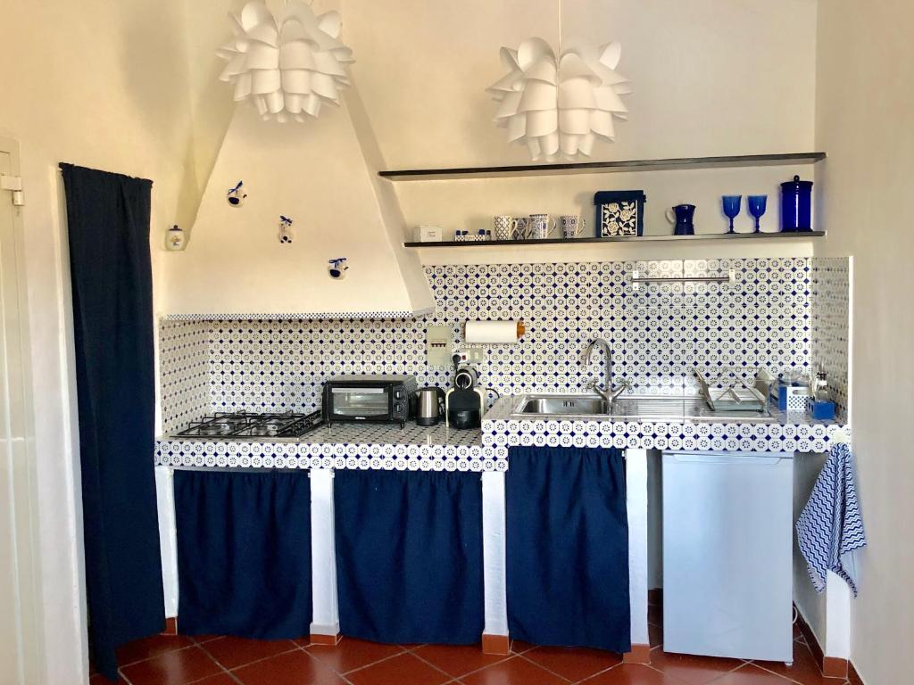 cocina con cortinas azules y encimera en La Casa di Dory, en Génova