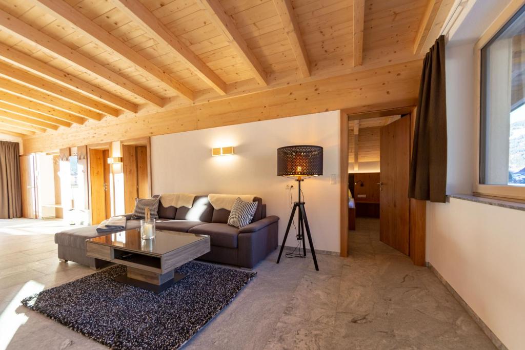 a living room with a couch and a table at Alpen Apart Heiss - DELUXE XL Apartments in Prutz