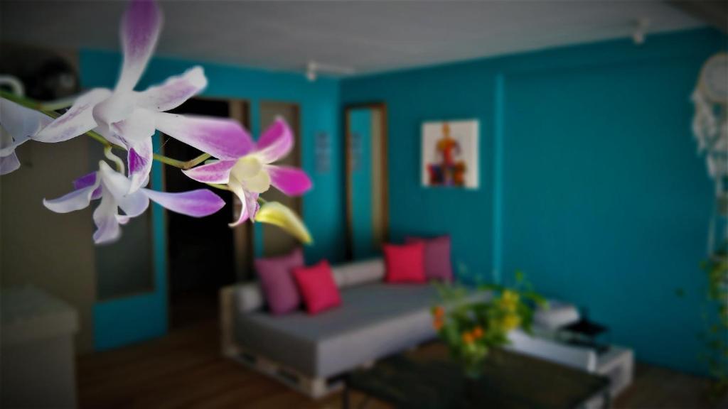 a living room with a couch and purple and white flowers at Meno Suites in Gili Meno