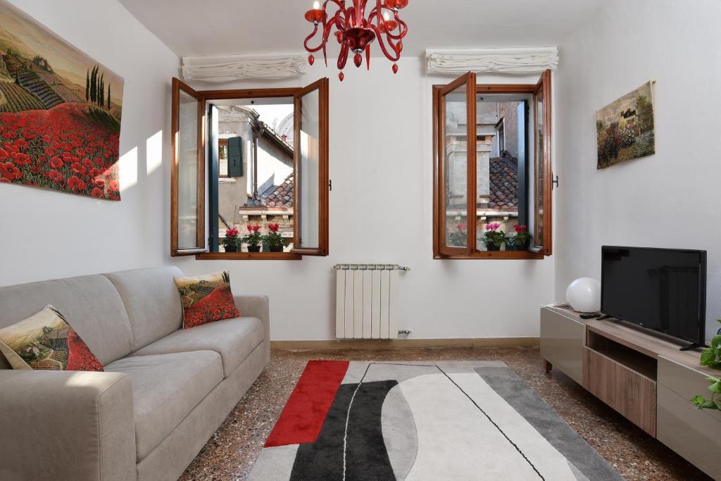 een woonkamer met een bank en een tv bij Appartamento Fabris in Venetië