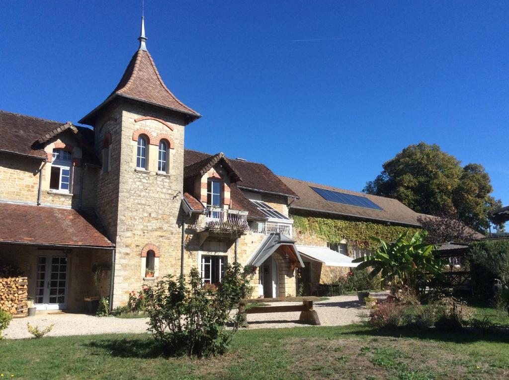 an old brick building with a tower on a yard at Chambres d'hôtes Le Relais de la Perle in Le Vernois