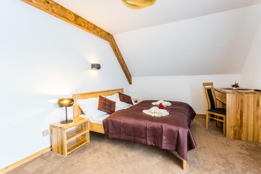 a bedroom with a bed with a table and a desk at Hotel Palatín in Oravský Podzámok