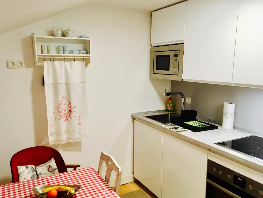 une petite cuisine avec une table et un four micro-ondes dans l'établissement Ferienwohnung Bergliebe inklusive SommerBergBahnTicket, à Oberstdorf
