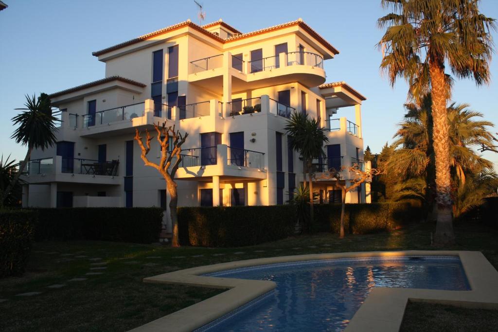 ein großes weißes Haus mit einem Pool davor in der Unterkunft Apartment close to the Beach in Denia