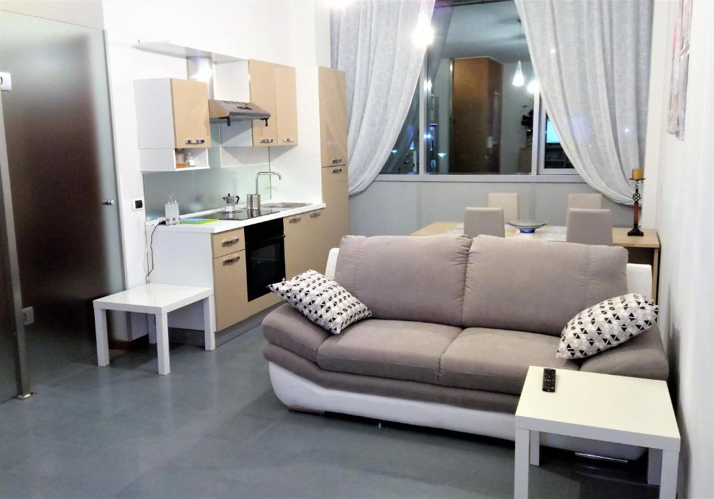 a living room with a couch and a kitchen at Appartamento Piazza dei Popoli in San Giovanni Teatino