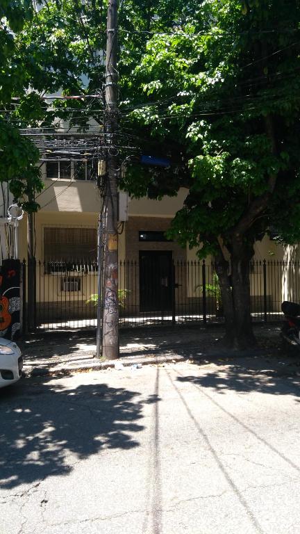a fence in front of a building with a tree at Flat Botafogo in Rio de Janeiro