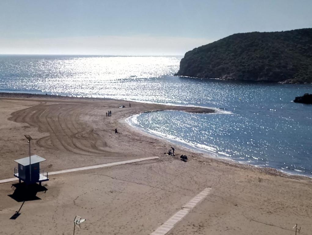 a group of people on a beach near the water at Edificio La Isla in Puerto de Mazarrón