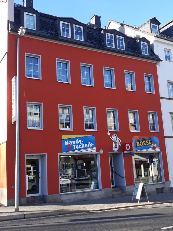 a red building on the corner of a street at Pension Tiffany in Chemnitz