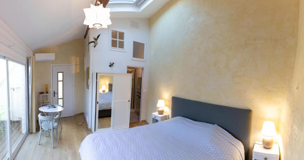 Schlafzimmer mit einem weißen Bett und einem Spiegel in der Unterkunft Chambre indépendante à Carcassonne in Carcassonne