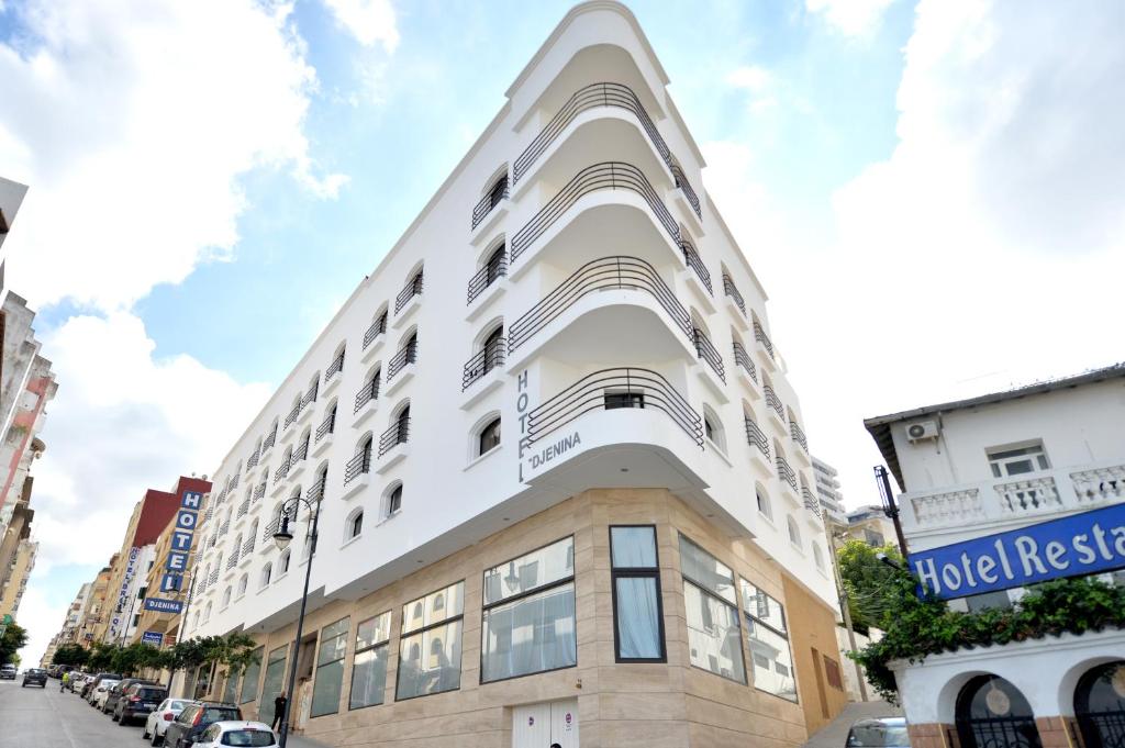 a building with a white facade on a city street at Hotel El Djenina in Tangier