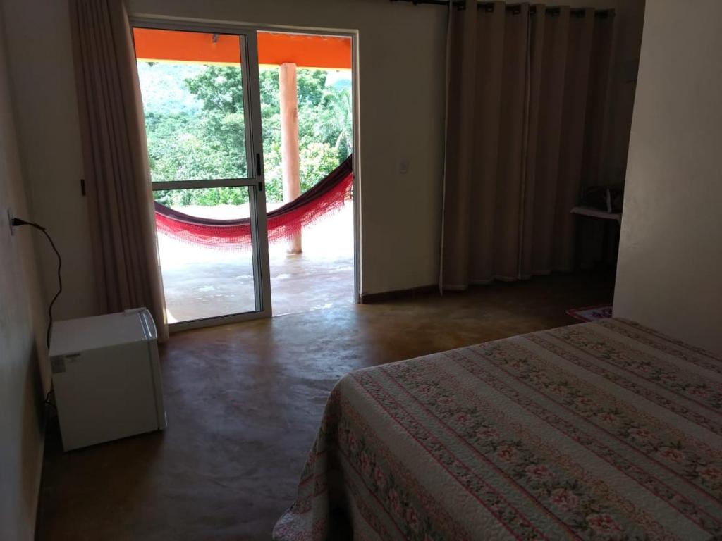 Praia do Jatobá في ساو خورخي: غرفة نوم بسرير وباب زجاجي منزلق