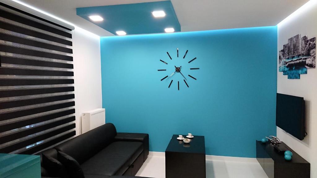 キェルツェにあるApartament Exclusive Blueのリビングルーム(ソファ付)、青い壁の時計