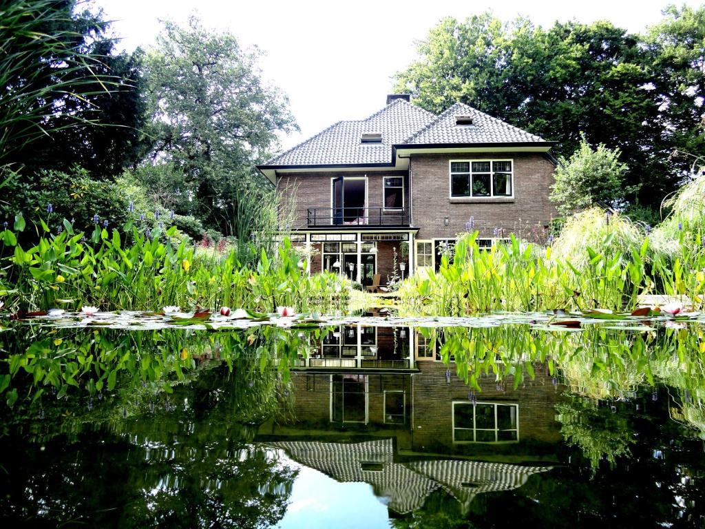 a house reflected in the water of a pond at Apartment in Romantic Villa in Bilthoven