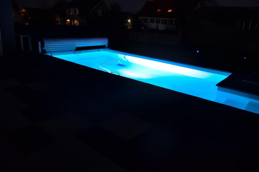 ein Pool in der Nacht mit blauen Lichtern in der Unterkunft Gîtes Spa Strasbourg - La Villa 14 in Furdenheim