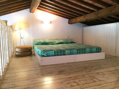 sypialnia z łóżkiem i drewnianą podłogą w obiekcie Appartamento elegante a Marina di Campo w mieście Campo nell'Elba