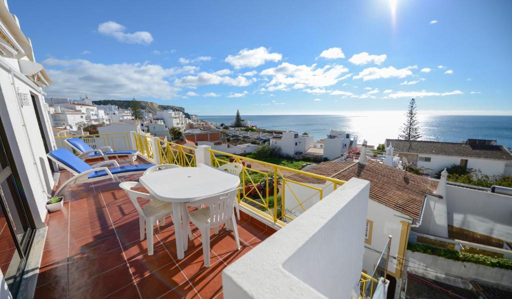 un balcon avec une table et des chaises et l'océan dans l'établissement Luz Beach Ocean Front Apartment, à Luz