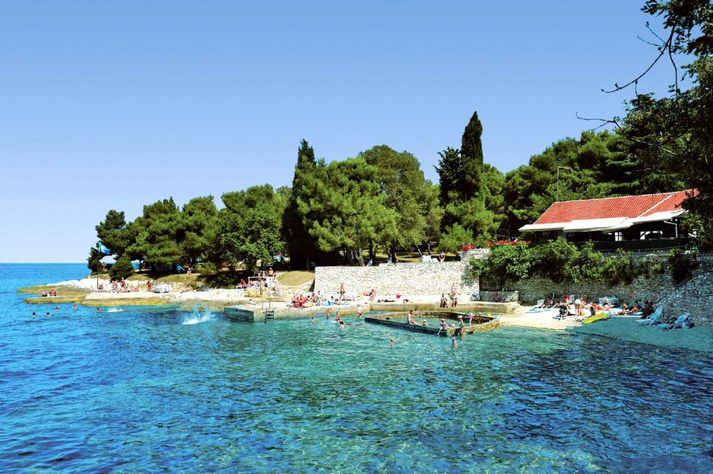 a group of people on a beach in the water at Apartments Bellevue Plava Laguna in Poreč