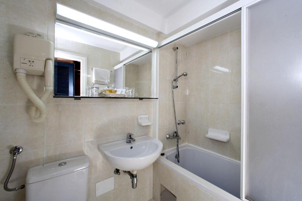 a bathroom with a sink and a toilet and a shower at Apartments Bellevue Plava Laguna in Poreč