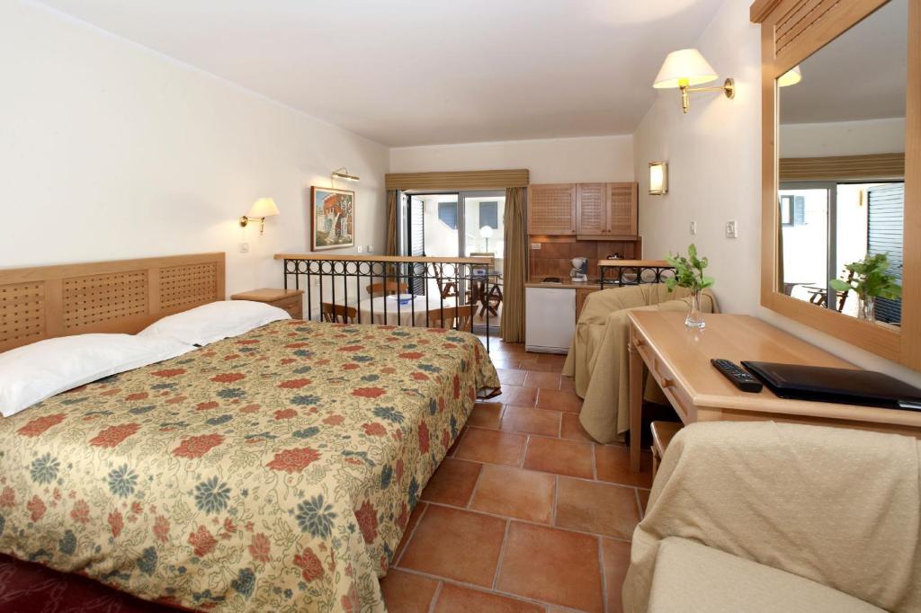 a bedroom with a bed and a table and a kitchen at Apartments Bellevue Plava Laguna in Poreč