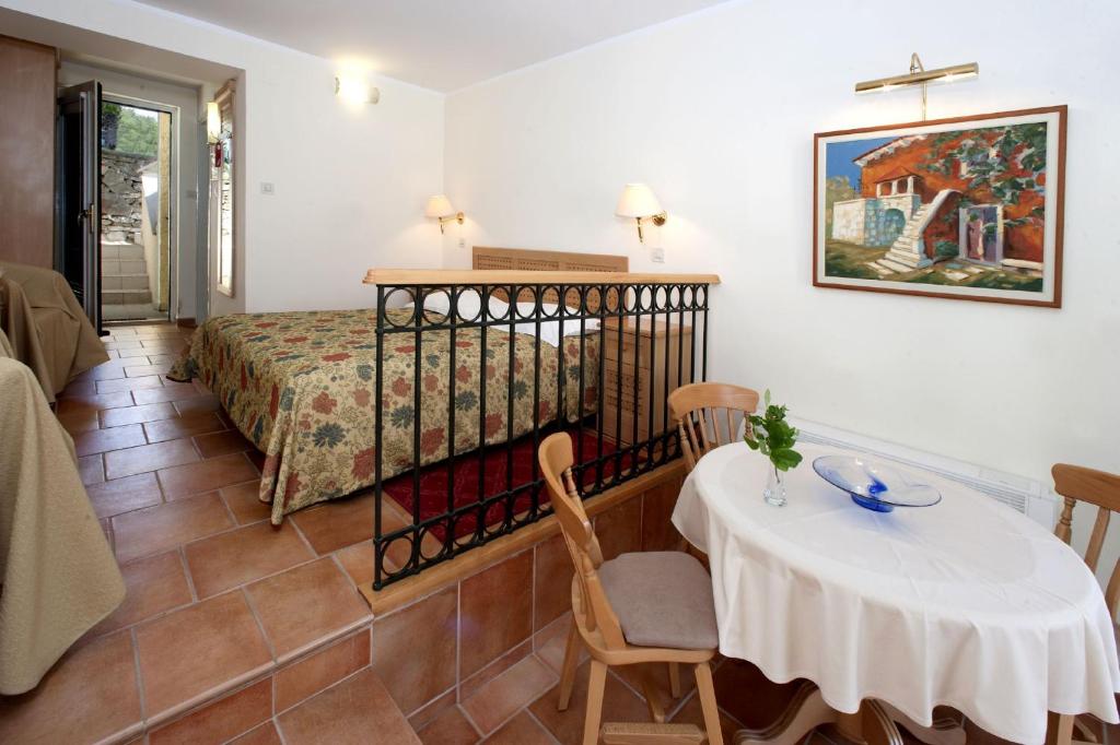 a room with a table and a bed and a table and chairs at Apartments Bellevue Plava Laguna in Poreč